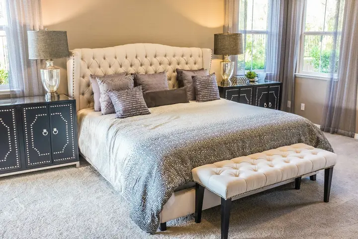 Cama vestida com linho claro, em luz quente, sem pessoas.