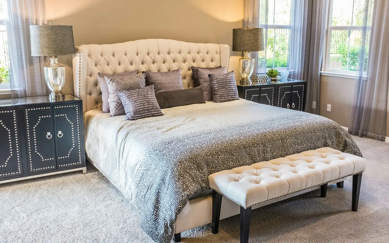 A bed dressed in pale linen, in warm light, with no people.